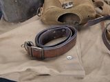 a brown bag and a brown belt on a tan cloth