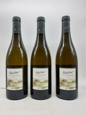trois bouteilles de vin posées sur une table blanche