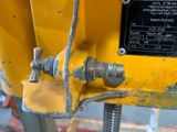 a close up of a yellow machine that has a bolt on it