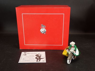 une petite figurine représentant un homme à vélo, à côté d'une boîte rouge