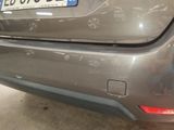the rear end of a silver car with scratches on it ' s bumper