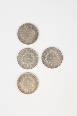 three silver coins sitting on top of each other on a white surface