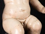 a small statue of a baby sitting on a rock
