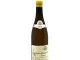 a bottle of white wine sitting on top of a white table