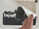 a hand holding a piece of paper over a picture of a castle