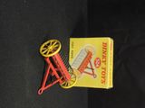 a red and yellow toy wheel and a book on a black surface