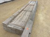 un long banc en bois posé au milieu d'un champ de terre battue