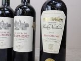 three bottles of red wine are lined up on a table