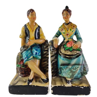 pair of ceramic figurines of a woman and a man sitting on a bench