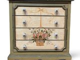 an image of a small chest of drawers with flowers painted on it
