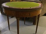 une petite table au plateau vert dans une pièce