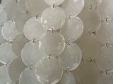 a chandelier made out of plastic discs hanging from a ceiling