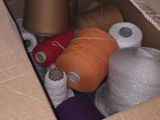 many spools of thread in a box on the floor