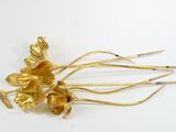 a gold flower brooch on a white surface