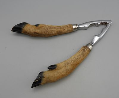 pair of dog paw claws with metal handles on a white surface