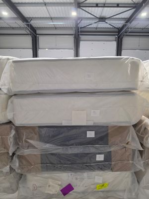 many mattresses stacked on top of each other in a warehouse