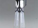 an antique silver plated glass pitcher with a black handle