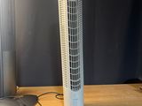 un ventilateur posé sur une table, à côté d'une souris et d'un clavier