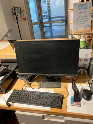 a desk with a computer, keyboard, mouse, and other items on it
