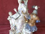 une figurine représentant une femme en train de lire un livre avec deux enfants