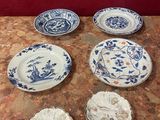 plusieurs assiettes bleues et blanches posées sur une table, avec un mur rouge en arrière-plan