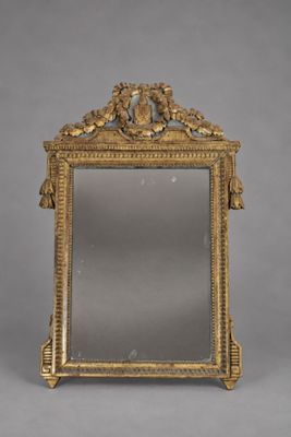 un miroir ancien avec un cadre doré et un motif représentant un oiseau