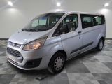 the silver van is parked on a checkered floor in the garage