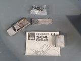 a small toy car sitting on top of a table next to a piece of paper