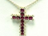 une image représentant un collier orné d'une croix composée de pierres rouges