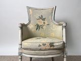 an old chair with floral upholstered upholstered back and arms