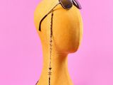 une tête de mannequin portant des lunettes de soleil sur un fond rose