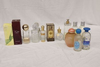 de nombreux flacons de parfum posés sur une surface blanche