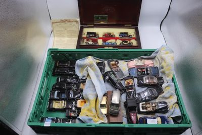 une boîte verte remplie de téléphones portables de différentes marques, posée sur une table