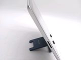 a tablet computer sitting on a stand on a white surface