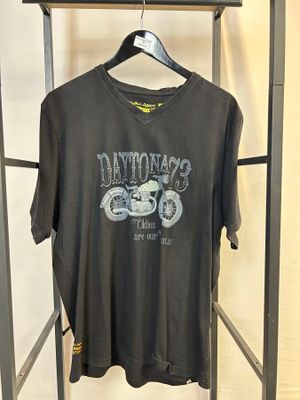 un t-shirt noir suspendu à un portant dans un magasin de vêtements