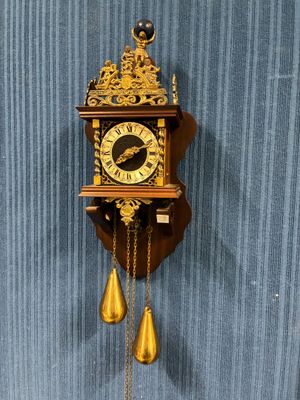 une horloge accrochée au mur par une chaîne