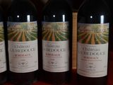 three bottles of red wine are lined up on a table