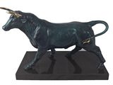 statue d'un taureau sur un socle noir, sur fond blanc