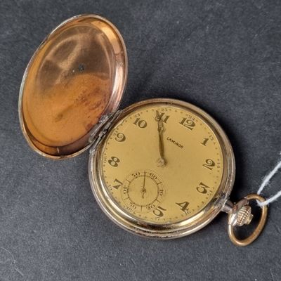 une montre à gousset en or avec une chaîne autour d'elle