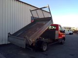a red truck with a metal bed parked in front of a building