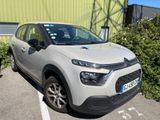 une voiture argentée garée dans un parking à côté d'un bâtiment
