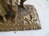 une statue en bronze d'un homme et d'un chien