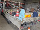 un camion garé dans un garage, avec du matériel de chantier à l'arrière