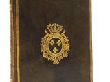 an old book with a gold emblem on the cover