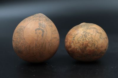 two eggs with designs on them sitting next to each other