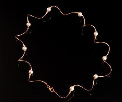 un collier en or orné de perles sur fond noir