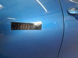 a close up of a blue car with a sticker on it