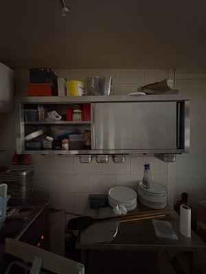 a microwave that is on top of a shelf in a kitchen