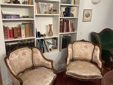 two chairs and a table in a room with bookshelves