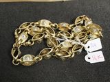 bracelet plaqué or avec des clochettes et une étiquette sur un fond noir